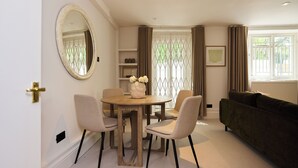 Un espace repas comprenant une table ronde, des chaises, un miroir et un canapé.