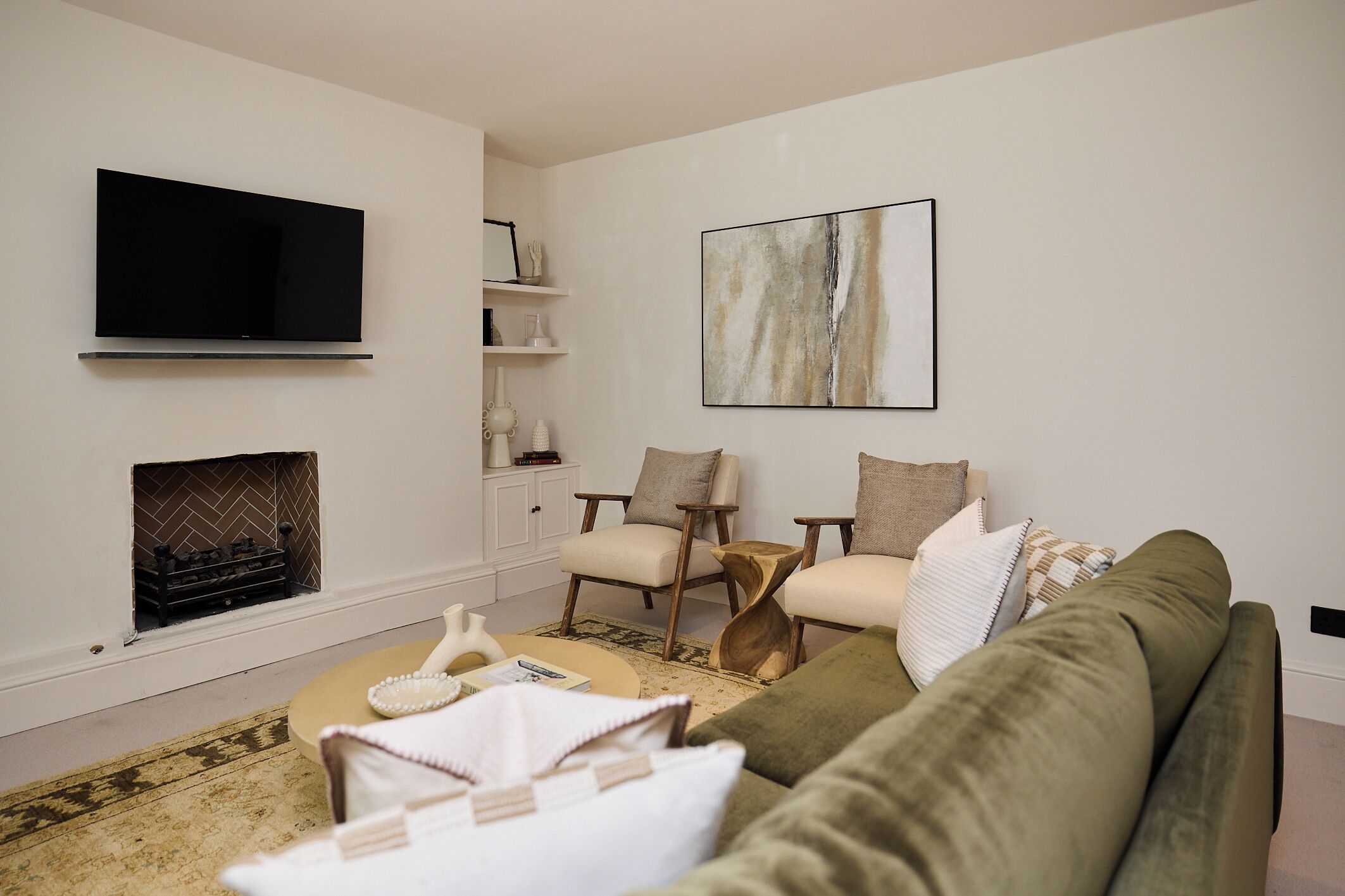 A living room with a flat-screen TV, a fireplace, a sofa, and a coffee table.