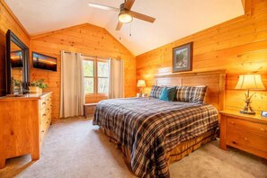 A bedroom with a bed, bedside tables, a dresser, a ceiling fan, and a window with curtains. - Bear Ridge | Luxury 3BR Smoky Mountain Cabin | Hot Tub, Game Room & Pool Access (Gatlinburg)