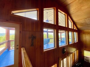 A wooden interior with multiple windows, a ceiling fan, and a view of the outdoors. - Heated Pool, Cabana, Luxury, Mt. Views, 2 minutes 2 Frio River & Garner Park! (Concan)