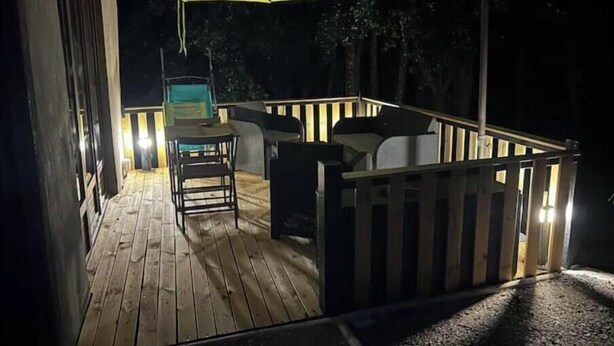 A wooden deck with outdoor furniture and a green umbrella. - Gîte du Tacot 21 – A peaceful retreat in the heart of nature (Saulieu)