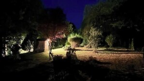 A nighttime outdoor area with a pathway, trees, and a small illuminated structure. - Gîte du Tacot 21 – A peaceful retreat in the heart of nature (Saulieu)