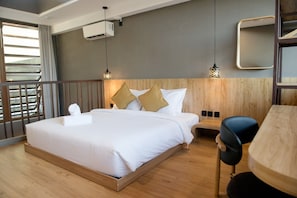 A hotel room with a large bed, wooden headboard, two bedside tables, a desk, and a chair. - Cozy Mezzanine Loft Bedroom and Master Suite with Shared Pool & Co-Work Deck (badung)
