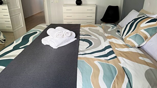A hotel room with a bed, a bedside table, a lamp, and a wall-mounted vase. - Apartment in Los Cristianos - Ocean View (Arona)