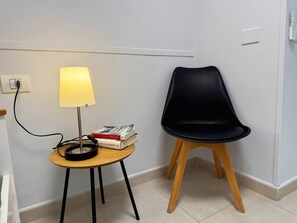 A small room with a round table, a lamp, a chair, and a book. - Apartment in Los Cristianos - Ocean View (Arona)