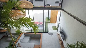 Un interior moderno con una pared de vidrio, una zona de estar y vistas al exterior.