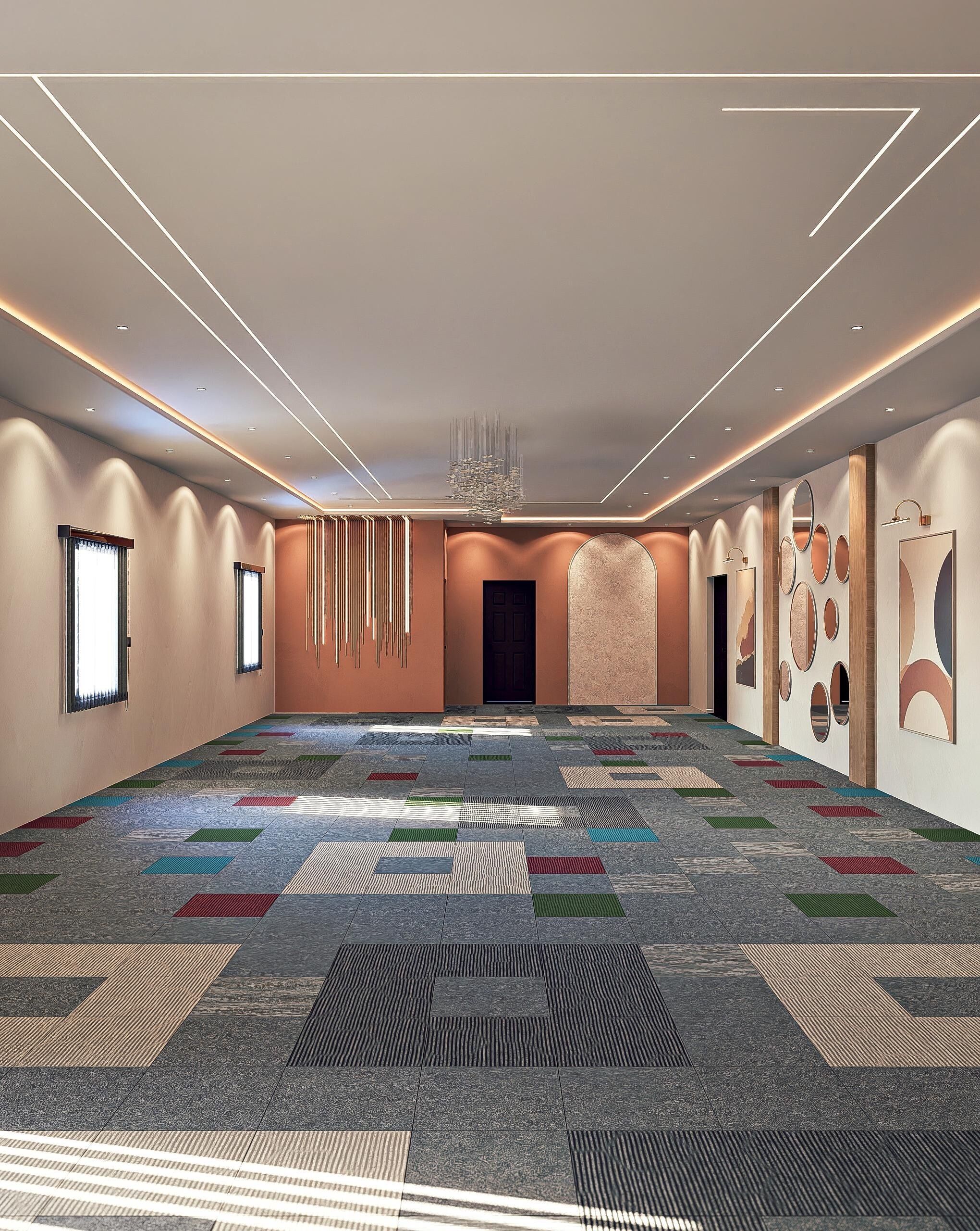 A spacious conference room with a patterned carpet, recessed lighting, and a large door at the far end.