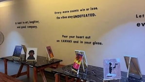 A gallery with artwork on easels and benches. - The Haven Hub (Abeokuta)