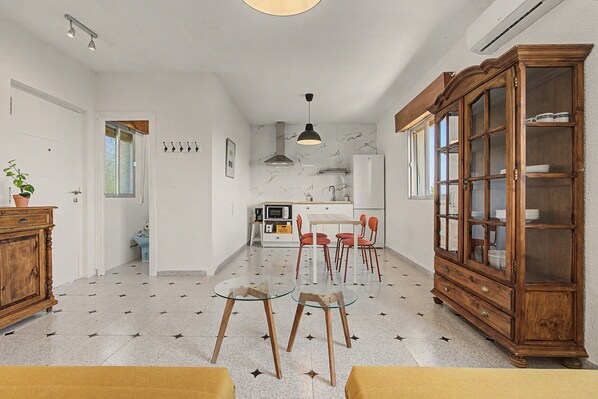 A modern kitchen with a dining area, a wooden cabinet, and a ceiling light fixture.