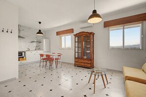 Une cuisine moderne avec un coin repas, un meuble en bois et une vue par la fenêtre.