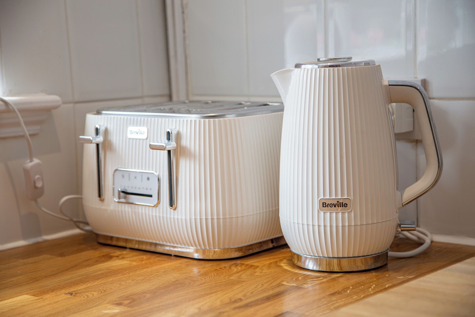 Une cuisine avec un grille-pain et une bouilloire de la marque Breville, posés sur un plan de travail en bois.