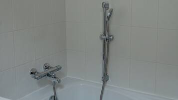 Un baño con bañera, ducha y retrete.