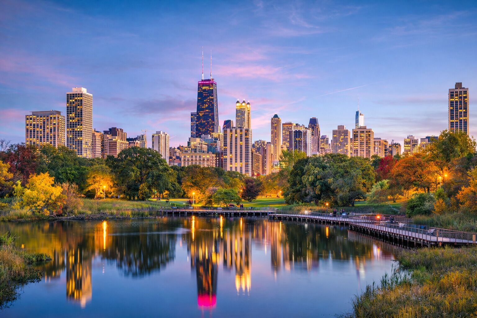 A city skyline with high-rise buildings, a park with trees, and a calm lake reflecting the buildings.