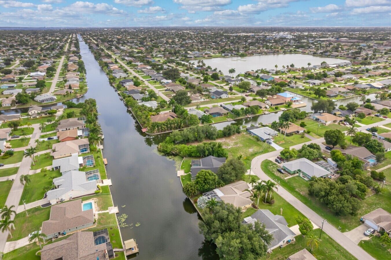 Een woonwijk met huizen, een rivier en een groot waterlichaam.
