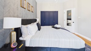 Un dormitorio con cama, lámpara de noche y armario.