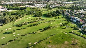 Ilmakuva golfkentästä, jossa on hiekkabunkkereita, ja jonka ympärillä on asuinrakennuksia ja viheralueita.