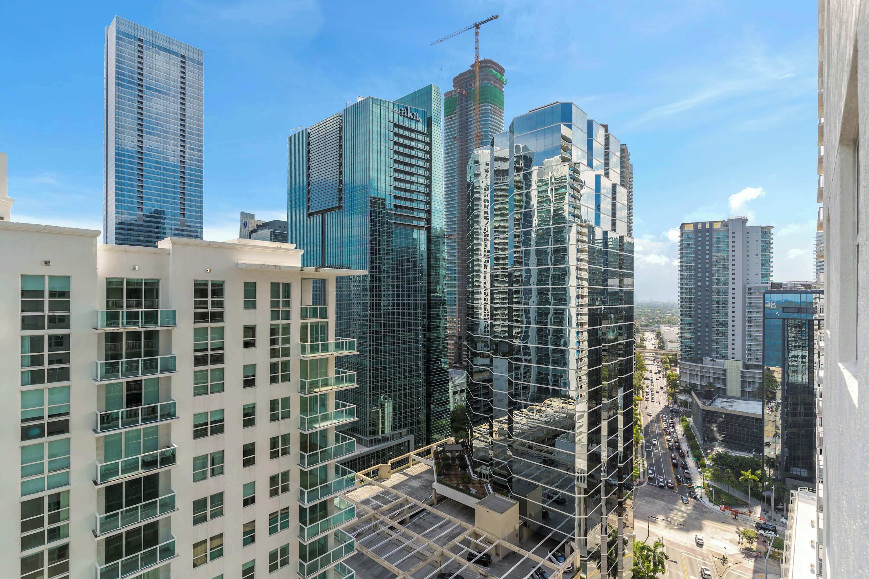 A cityscape with modern high-rise buildings, including a construction site.
