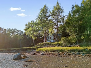 A house surrounded by trees and a rocky shoreline. - Camp Avaliz - Ocean-view for 2 with a queen bedroom, kitchenette, Wi-Fi and AC (Gouldsboro)