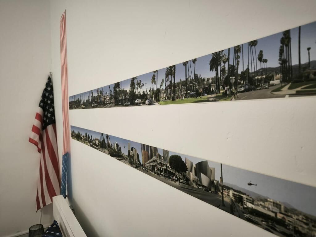 Pared con tres fotografías que muestran escenas urbanas, una bandera estadounidense y un cubo de basura.