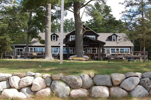 A large lodge with a covered deck and outdoor seating area. - Musky Inn North: 5  BR, 3  BA Lodge in St. Germain, Sleeps 10 (St. Germain)