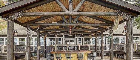 Un pabellón de madera con una zona de bar y asientos al aire libre.