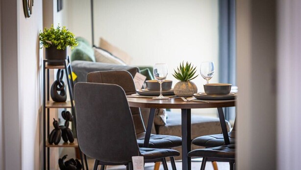 A dining area with a table set for two, featuring a plant, a pineapple, and a bowl. - Birmingham City Retreat No 151 (Birmingham)