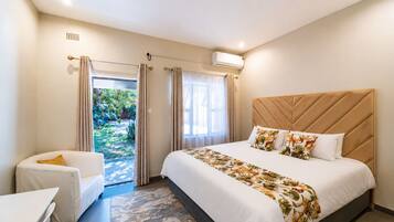 Ein Hotelzimmer mit Bett, Stuhl, Fenster und Klimaanlage.