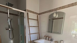 A bathroom with a glass shower enclosure, a white sink with a mirror above it, and a wooden ladder leaning against the wall. - Les Albères Bed & Breakfast Suite with a view of the pool and terrace (Villelongue-dels-Monts)