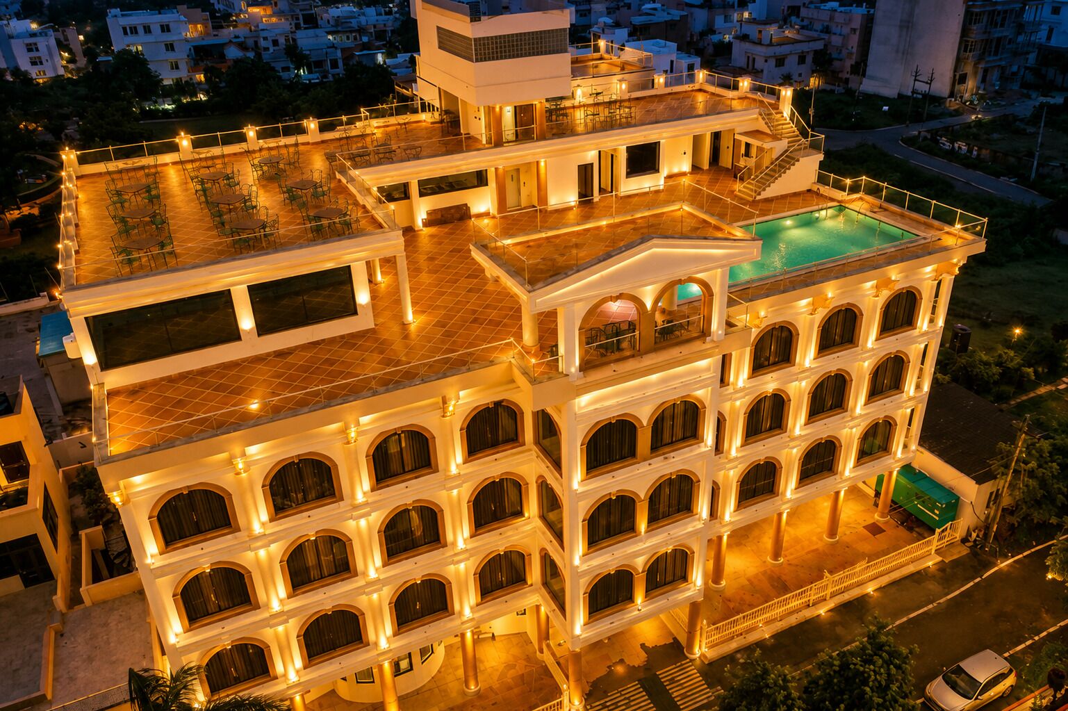 A multi-story building with a rooftop pool and outdoor seating area.