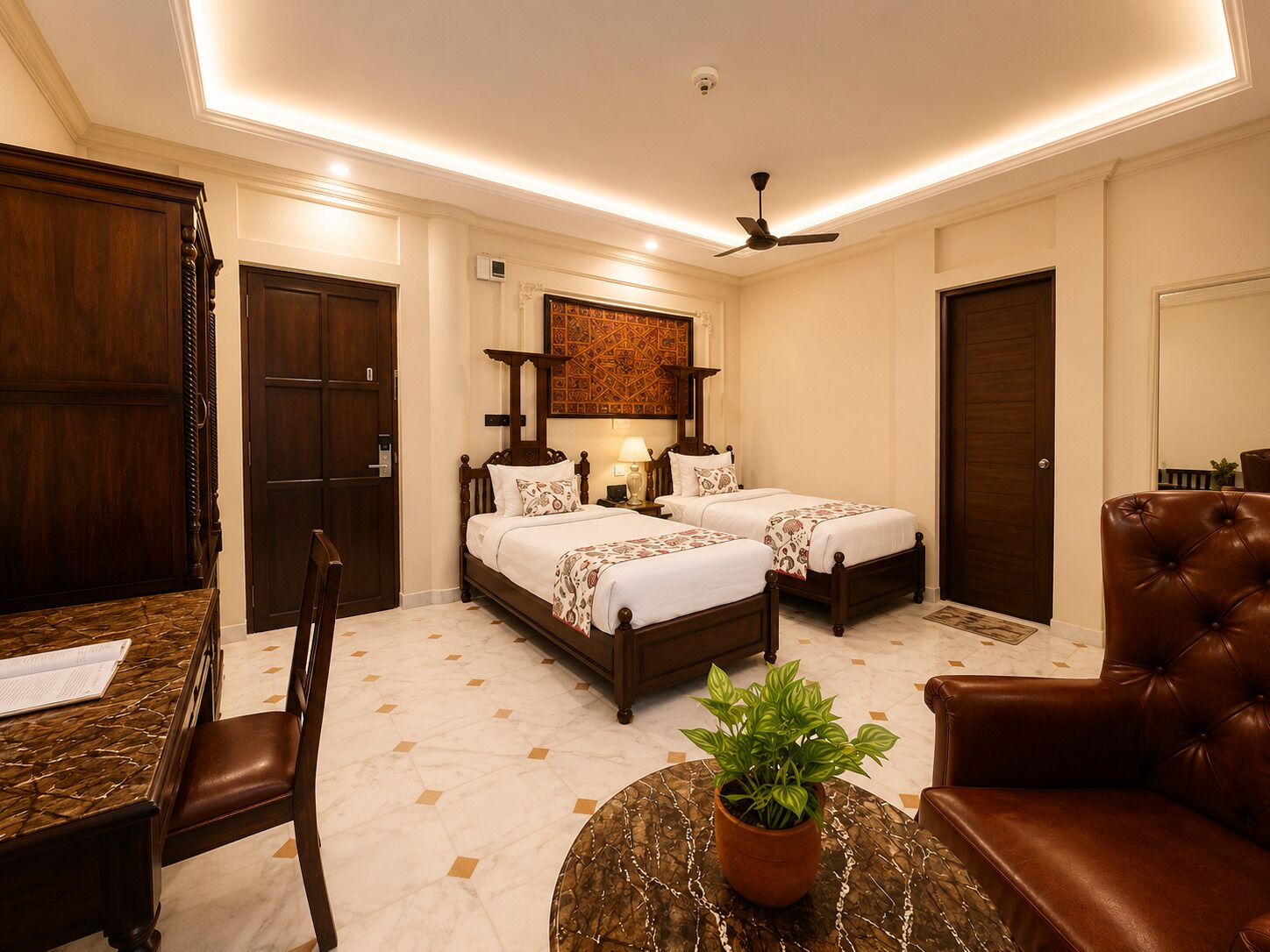 A hotel room with two beds, a desk, a chair, a ceiling fan, and a potted plant.