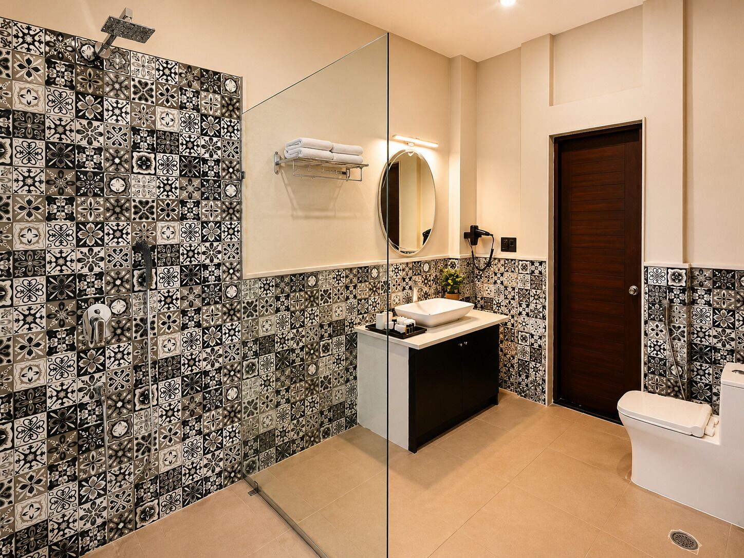 A bathroom with a tiled shower wall, a mirror, a sink with a towel rack, and a toilet.