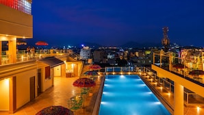 A rooftop swimming pool with a view of the cityscape at night. - Barliyas Heritage Boutique Hotel (Udaipur)