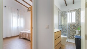 Une chambre à coucher avec un lit et une salle de bain avec douche et toilettes.