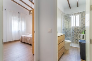 Ein Schlafzimmer mit einem Bett und einem Badezimmer mit Dusche und Toilette.
