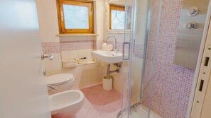 Ein Badezimmer mit Toilette, Bidet, Waschbecken und Dusche.