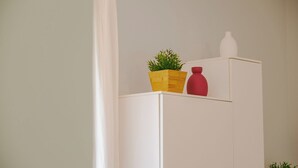 A white cabinet with a wooden planter and a red vase on top. - La Casa di Greta - One Bedroom Apartment, Sleeps 4 (Peschiera del Garda)
