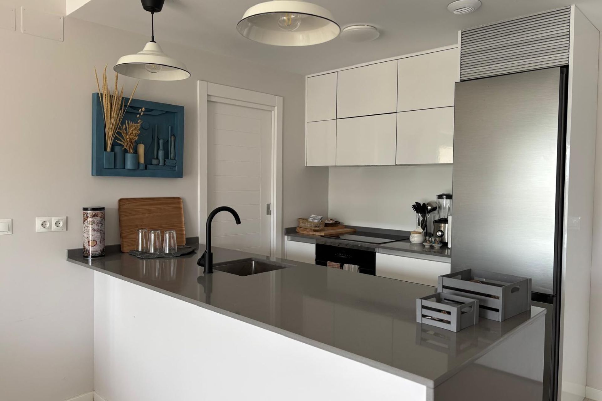 A modern kitchen with a central island, white cabinetry, and stainless steel appliances.