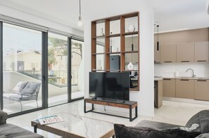 A modern living room with a TV, a glass coffee table, and a sofa. - Modern 1BR W/Balcony in Central Nicosia (Nicosia)