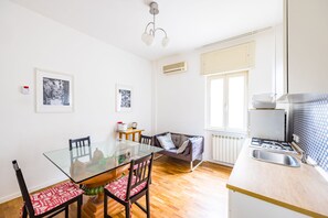Una cocina moderna con estufa a gas, un lavamanos y un comedor con mesa y sillas de vidrio.