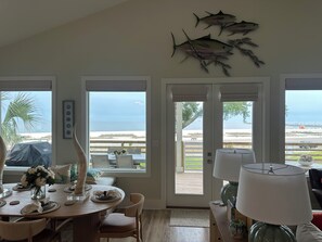 Zona pranzo con vista sull'oceano, una grande decorazione a forma di pesce sulla parete e un tavolo apparecchiato per quattro.