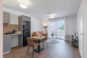 Un apartament modern amb cuina, zona de menjador i un balcó amb vistes.