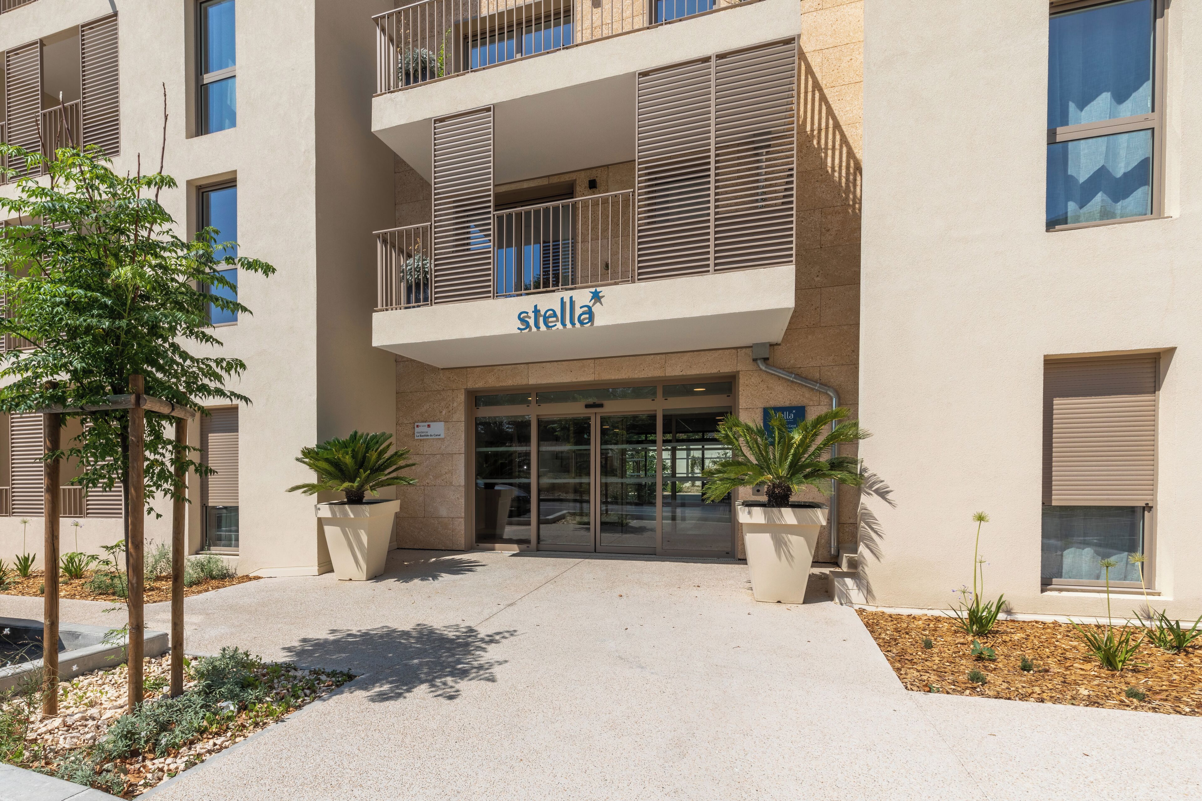 A multi-story building with a sign reading 'stella' at the entrance.