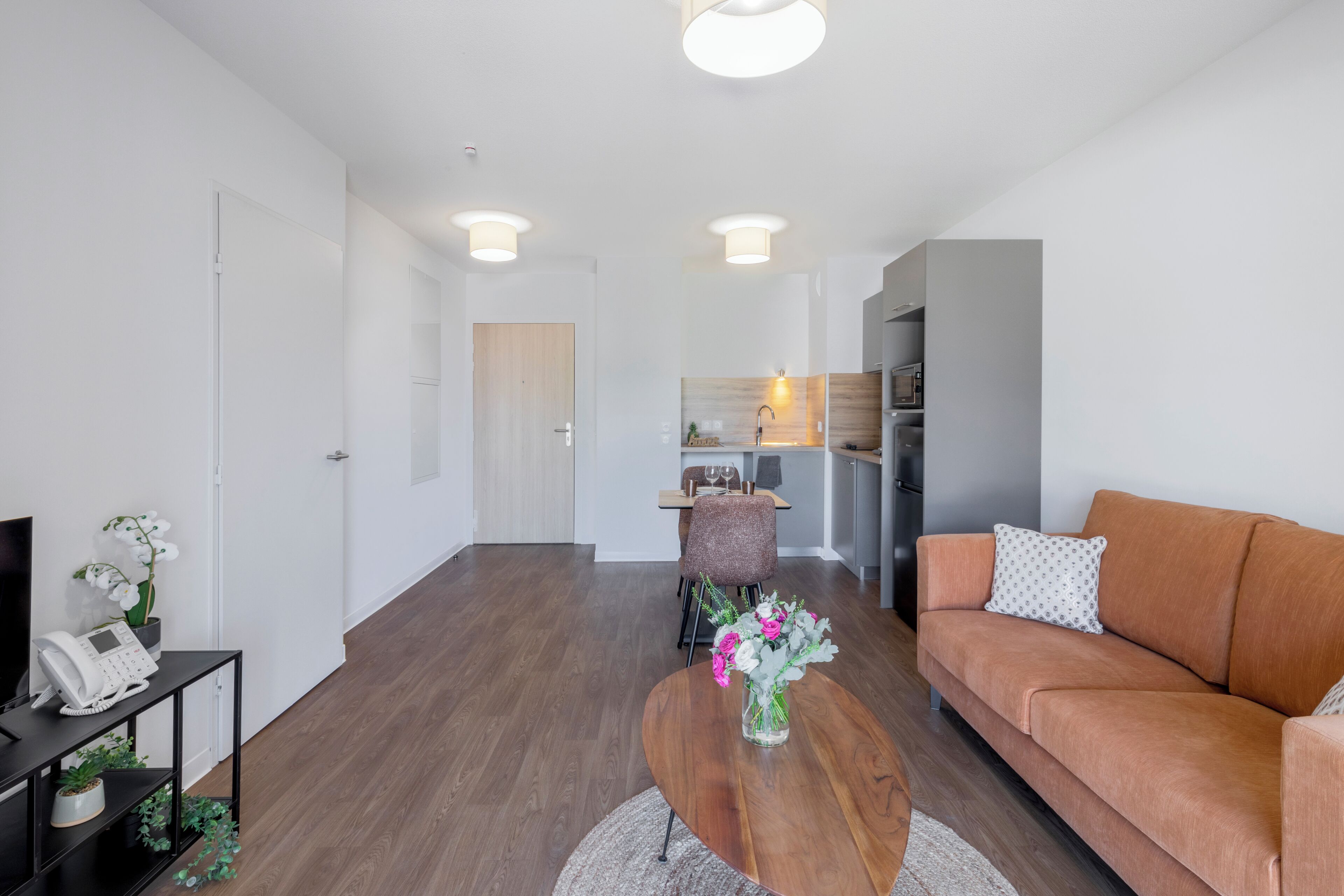 Una sala de estar moderna con una mesa de centro de madera, un sofá y un comedor con sillas y una mesa.