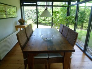 A dining table with wicker chairs, a glass bowl, and a hanging lamp. - Detached Bungalow, Perfect for Water Sports and Nature Enthusiasts (Kamperland)