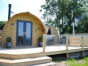 A wooden cabin with a large arched entrance, a deck, and a hot tub. - The Lodge at Brambles Farm Sleeps 4 Hot Tub (Leek)