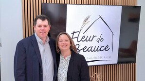 Zwei Personen stehen vor einem Schild mit der Aufschrift 'fleur de Beauce', im Hintergrund eine Holzvertäfelung.