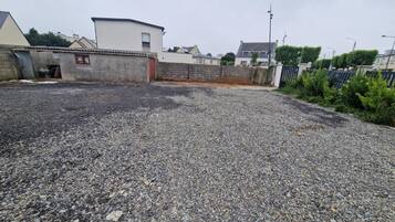 A gravel parking area with a building in the background.