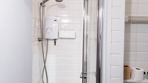 A shower with a control panel, a glass door, and a white tiled wall. - The Bay Apart-Hotel by Guestz (Morecambe)