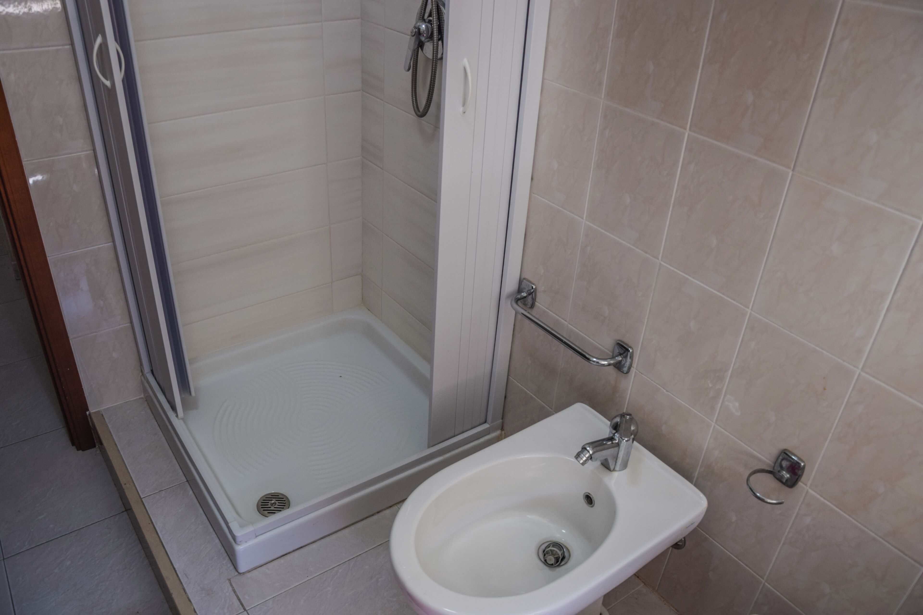 Ein Badezimmer mit Dusche, Waschbecken und Toilette.