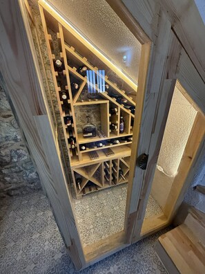 A wooden wine cellar with multiple shelves and bottles.